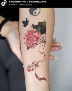 a woman's arm with tattoos and flowers on it