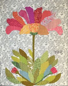 a quilted flower with leaves and flowers on it