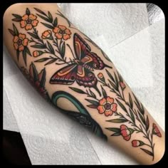 a butterfly and flowers tattoo on the arm