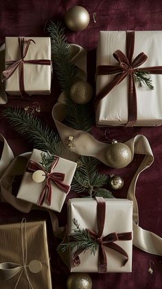 presents wrapped in white paper and tied with brown ribbon are sitting on a table next to christmas decorations