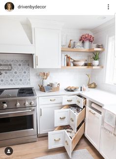 a kitchen with white cabinets and open drawers