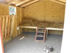 the inside of a barn with hay and other things in it, including two cats