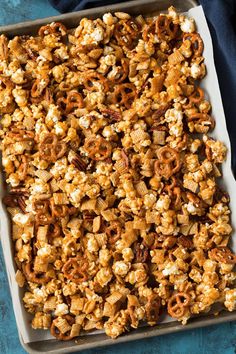 a tray filled with popcorn and pretzels on top of a blue table