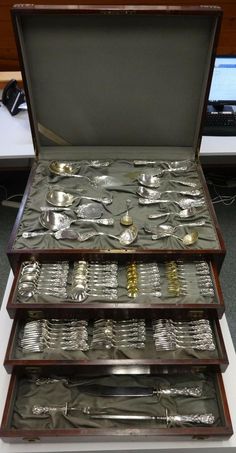 three trays filled with silverware sitting on top of a table