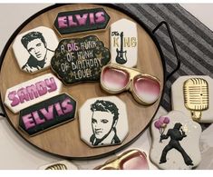 elvis presley cookies are arranged on a platter with sunglasses and other decorations around them