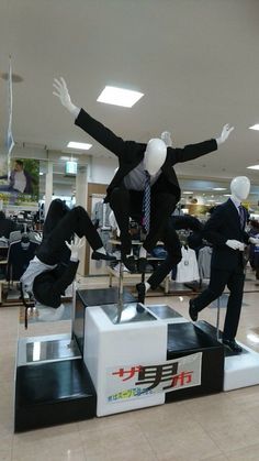 three mannequins dressed in suits and ties are jumping over an object