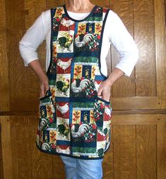 an older woman standing in front of a wooden door wearing a quilted apron with roosters on it