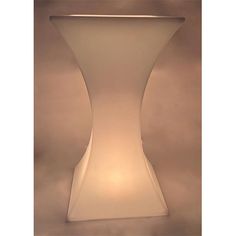 a white table with a light on it's side and an object in the middle