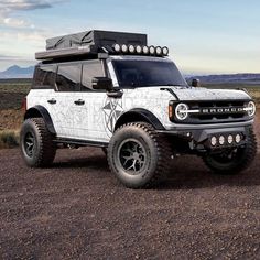 an off - road vehicle is parked in the desert