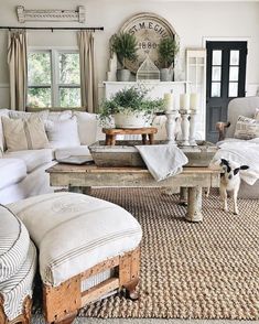 a living room filled with white furniture and lots of pillows on top of it's couch