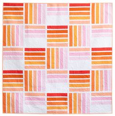 an orange and pink quilt on a white background