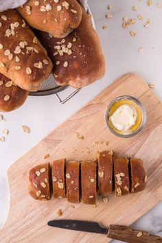 sliced loaves of bread on a cutting board with butter and honey in the background