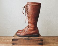 ꞊ Extraordinarily rare Cole Haan 1930's style knee high lace up boots in warm whiskey brown. ꞊ Thick solid leather, beautifully made. ꞊ Wingtip detailing. ꞊ brass grommets and textured sole. ꞊ Condition is good with minor creasing, a few scuffs/scratches on the toe and shaft, grommet patina, and some slight discoloration to laces from the grommets. I might replace the laces with waxed cord to make them easier to lace/unlace but the ones they have work fine. ||   M E A S U R E M E N T S   || Labeled As: 8B Fits Like: true to size with thin socks Ball: 4" sole: 10.75" Heel: 1.25" Total Height: 15" Vintage Boots With Laces For Fall, Vintage Fall Boots With Laces, Vintage Fitted Boots With Laces, Vintage Lace-up Boots, Vintage Leather Knee-high Lace-up Boots, Vintage Brown Lace-up Boots, Vintage Fitted Lace-up Boots For Fall, Fitted Vintage Lace-up Boots For Fall, Vintage Brown Boots With Laces