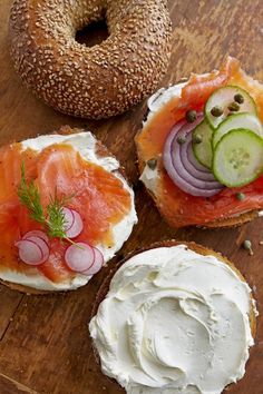 bagel with cream cheese, cucumber and smoked salmon on it next to a bagel bun