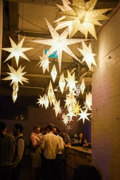 people are standing under stars hanging from the ceiling