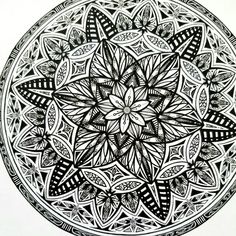 a black and white drawing of a flower in the middle of a circular design on paper