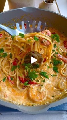 a pan filled with pasta and shrimp on top of a table