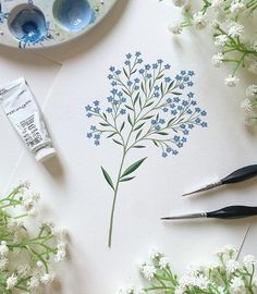 some paint and flowers on a table