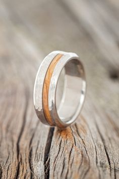 a wedding ring with two wood inlays on top of a piece of wood