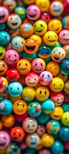 many different colored balls with smiley faces on them