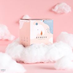 the box is sitting on top of some fluffy white clouds in front of a pink background