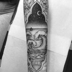 a man's arm with an ocean scene tattoo on it