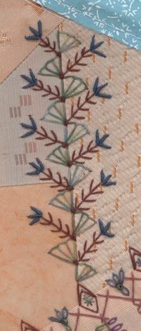 a close up of a piece of fabric with flowers and leaves on it, next to a blue ribbon