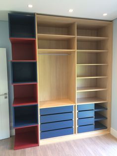 an empty room with several shelves and drawers in the center, including two blue bins