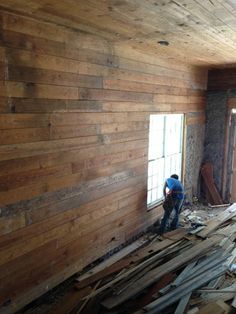 a man standing in the middle of a room that has been torn down and is being worked on