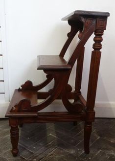 an old wooden chair sitting on top of a hard wood floor next to a white wall