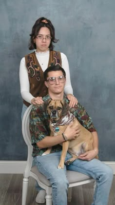 a man and woman sitting on a chair with a dog in front of their face