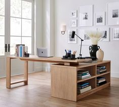 a wooden desk with a laptop computer on top of it next to a book shelf