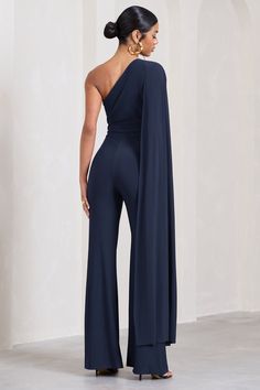 Every bit as elegant as it's name suggests, our navy Aurora jumpsuit is presented in sculpting stretch jersey with a sweeping cape sleeve that drapes from an asymmetric neckline. This wide-leg jumpsuit is not only versatile but made to flatter your unique figure whether you're headed to a bottomless brunch or an grand evening event this season. Features - Premium stretch jersey - Asymmetric neckline - Single cape sleeve - Invisible zip closure - Wide legs Sizing & Fit Model is 5’9" and wears UK size 8 / US size 4 Product Information Designed exclusively by Club L London Double layered with excellent stretch Premium jersey in Navy (95% Polyester, 5% Elastane) 85cm inside leg length SKU: CL126743 One Shoulder Cape, Dark Blue Wedding, Shoulder Cape, Bottomless Brunch, Club L London, Black Dress Prom, Black Tie Gala, Party Dress Long Sleeve, Asymmetric Neckline