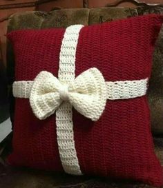 a red pillow with a white bow on it