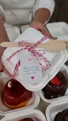 a person holding a paper tag over some cupcakes