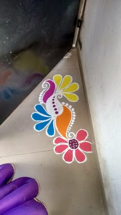 purple gloves are next to a sticker on the side of a metal object that looks like a flower