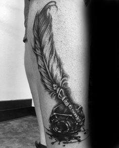 a black and white photo of a person with a tattoo on his leg that has a feather