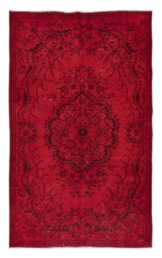 an old red rug with black and white designs on the middle, in front of a white background