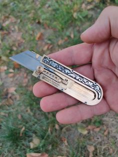 a person holding a small pocket knife in their left hand and it is open to show the blades