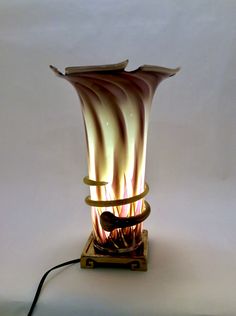 a lamp that is on top of a wooden stand with wires attached to the base