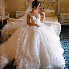 a woman in a wedding dress sitting on a bed