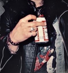 a man in a leather jacket holding a cup