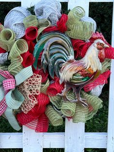 a rooster wreath on top of a white fence