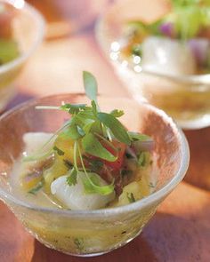 a small glass bowl filled with food on top of a wooden table next to other bowls