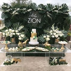 a table topped with cakes and desserts covered in greenery