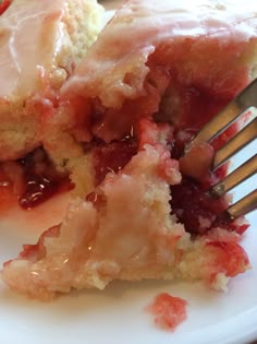 a piece of cake on a plate with a fork in it and some strawberries