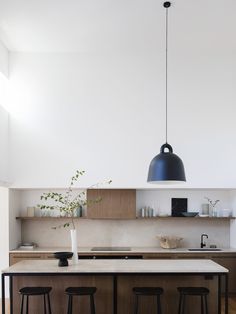 a kitchen with two stools and an island in front of the countertop area