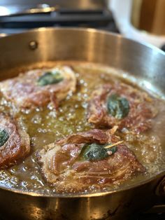 some meat is cooking in a pan on the stove