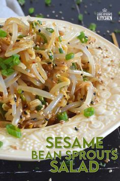 a white plate topped with noodles and veggies on top of a black table