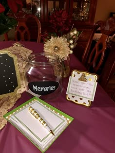 there is a table set up with place cards, napkins and a glass jar